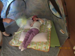 青のテントの中に別の女児の利用者さんが寝そべっている様子