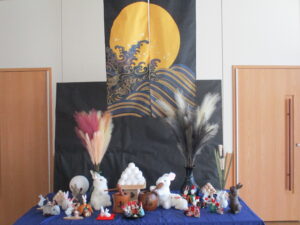 交流ホール正面の満月のタペストリーとウサギの餅つきの様子の置物の写真