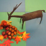 金属でできた鹿のオブジェと木の実の飾りの写真