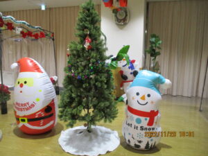 利用者さんのご家族から預かった品物を飾ったツリーとサンタと雪だるまの写真