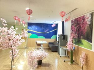 2階面会スペースに飾られた桜の立ち木の造花とぼんぼりの写真