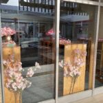 施設玄関のガラス張りの内側に桜の花飾りを飾った写真