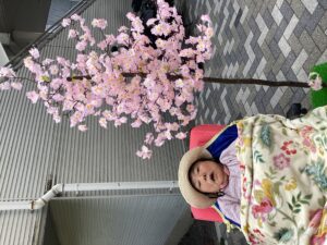 桜の立ち木飾りや和傘と一緒に外で記念撮影する利用者さんの写真６