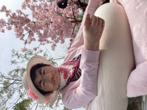 桜の立ち木飾りや和傘と一緒に外で記念撮影する利用者さんの写真５
