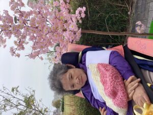 桜の立ち木飾りや和傘と一緒に外で記念撮影する利用者さんの写真４