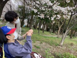 志賀公園内の桜の花と一緒に利用者さんとタッフを写した写真４