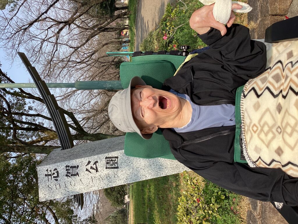 志賀公園の入り口で笑顔の利用者さんの写真