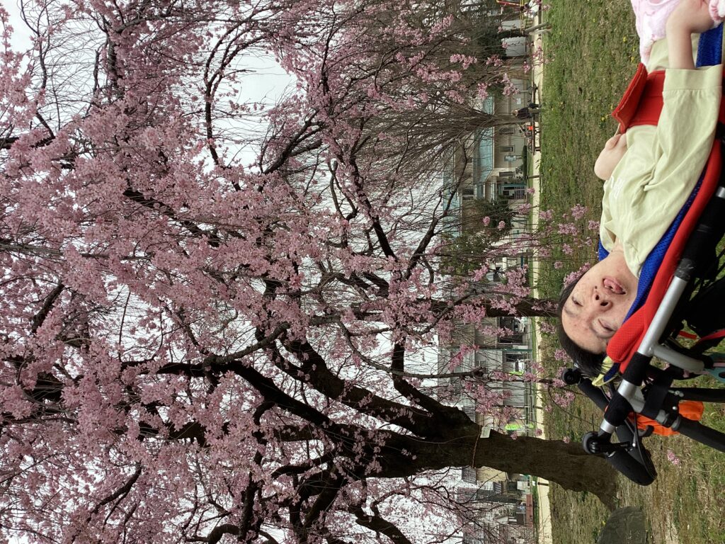 志賀公園内の桜の花と一緒に利用者さんを写したした写真１