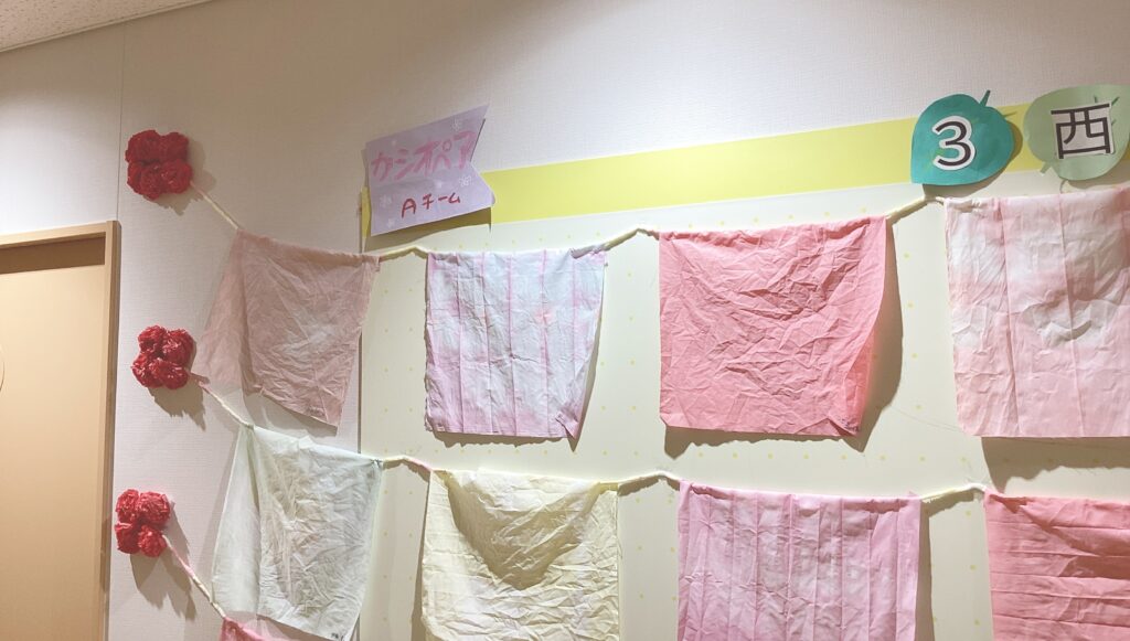フロア内の壁に展示された複数の絞り染めタオルの写真１