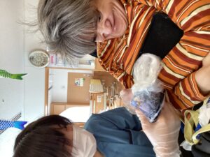 ビニール袋に入ったハンカチと染料をもみ込んでいる利用者さんの写真３
