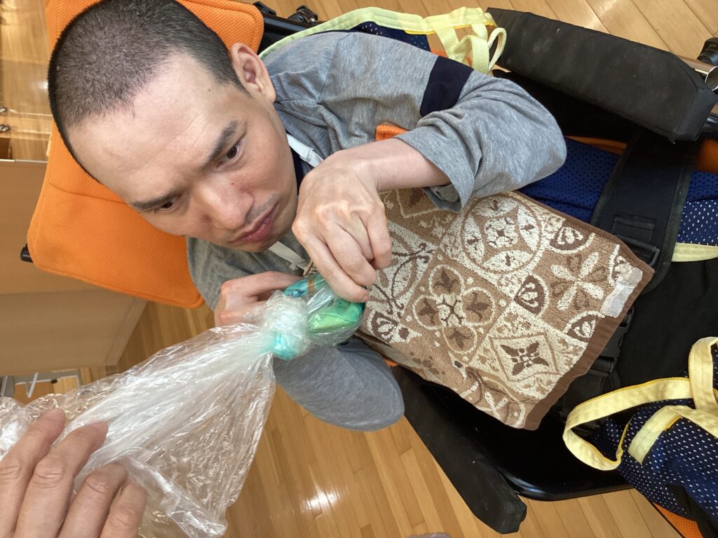 ビニール袋に入ったハンカチと染料をもみ込んでいる利用者さんの写真１