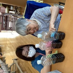 スタッフとどの色の染料にするか選んでいる利用者さんの写真