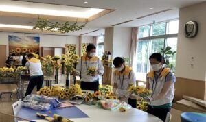 話し合いながらひまわりの花の飾り付けと行う男性と女性