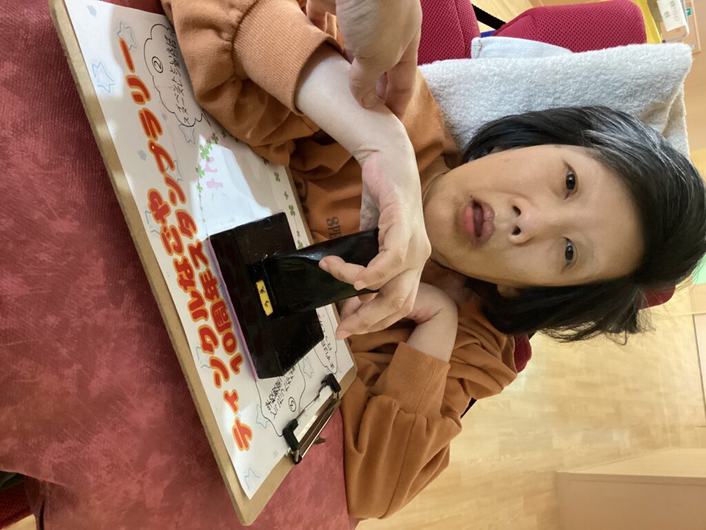 スタッフと一緒にスタンプを押す利用者さん１の写真