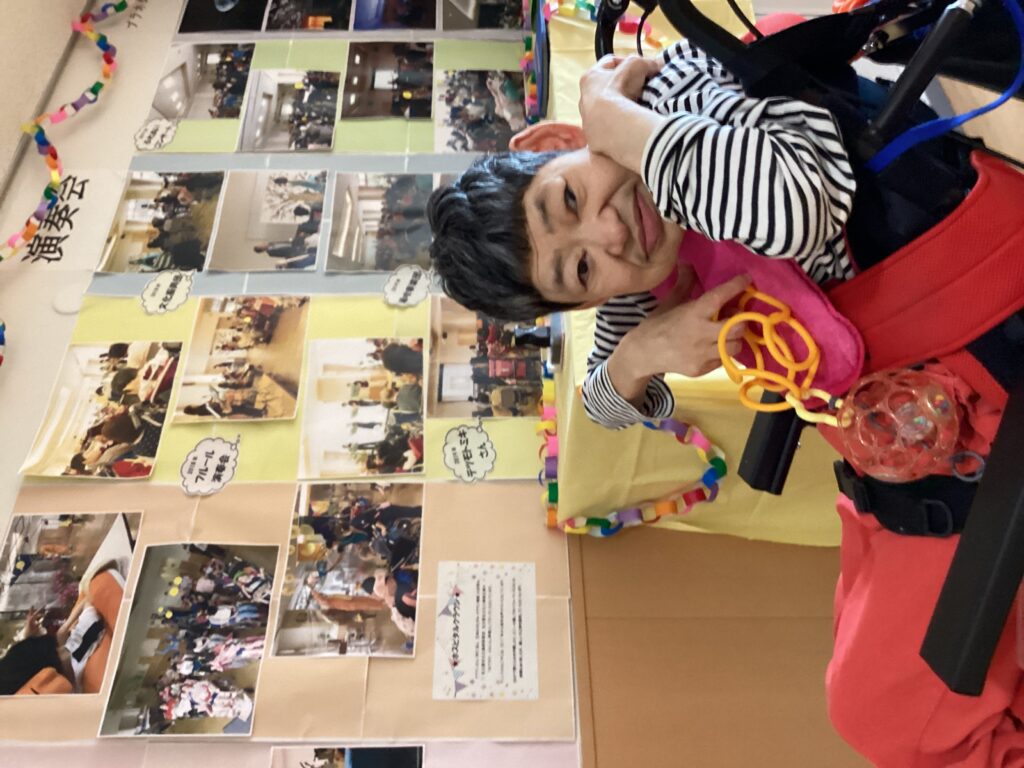思い出の写真をバックに利用者さんが写る写真
